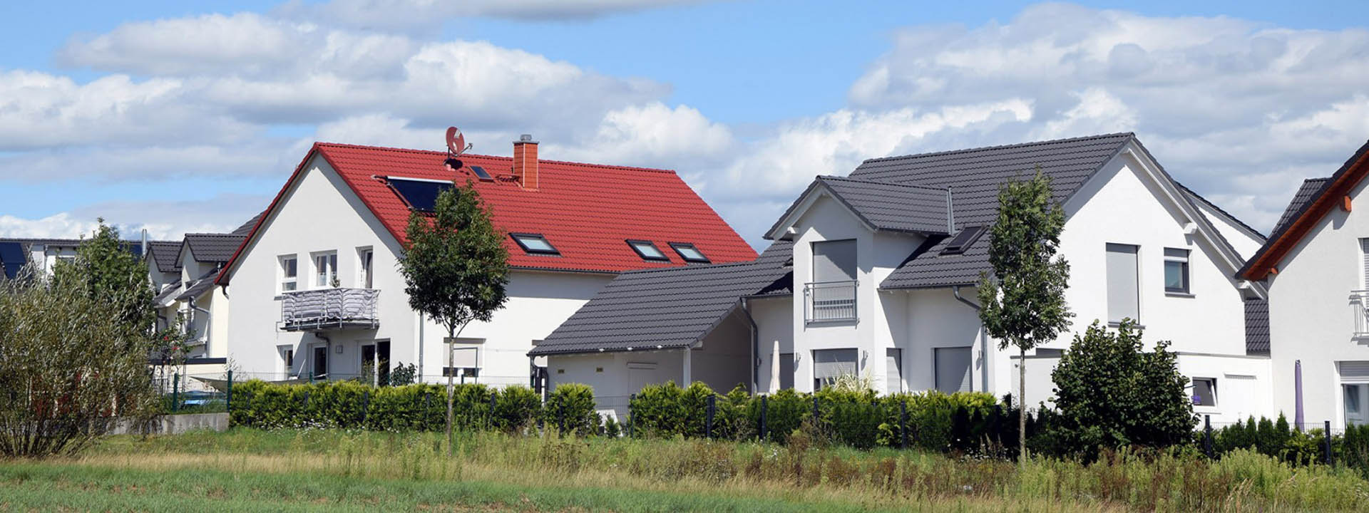 Moderne Einfamilienh&auml;user in einem Wohngebiet mit roten und grauen D&auml;chern