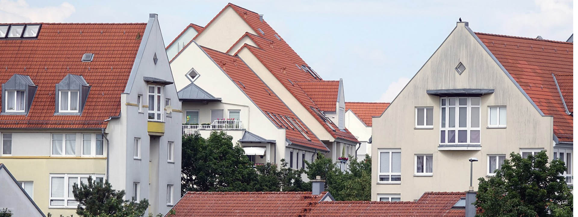 Mehrfamilienh&auml;user mit roten Ziegeld&auml;chern in einem Wohngebiet